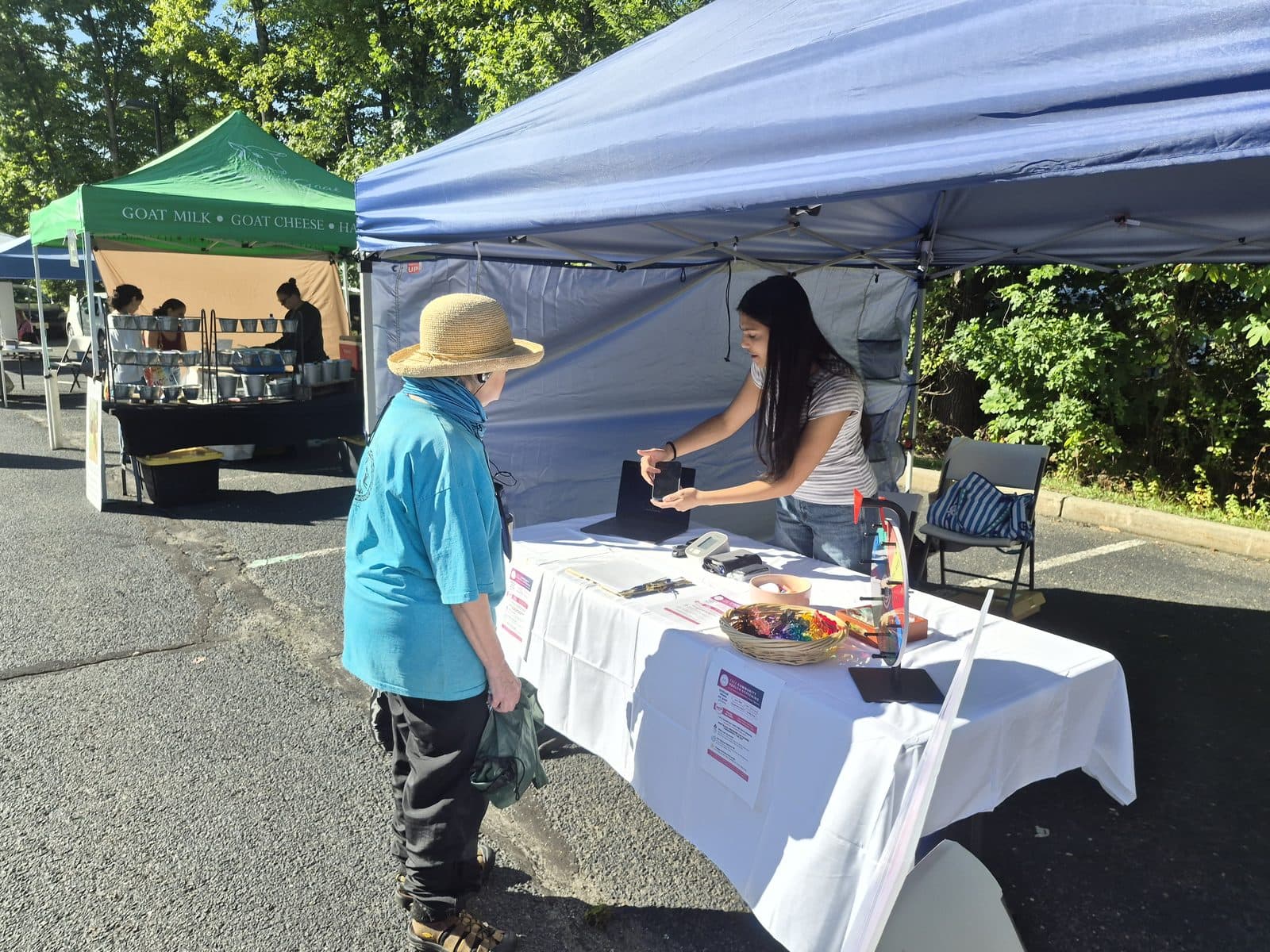 Showing a visitor the palm scan on a phone at the MoniVitals table