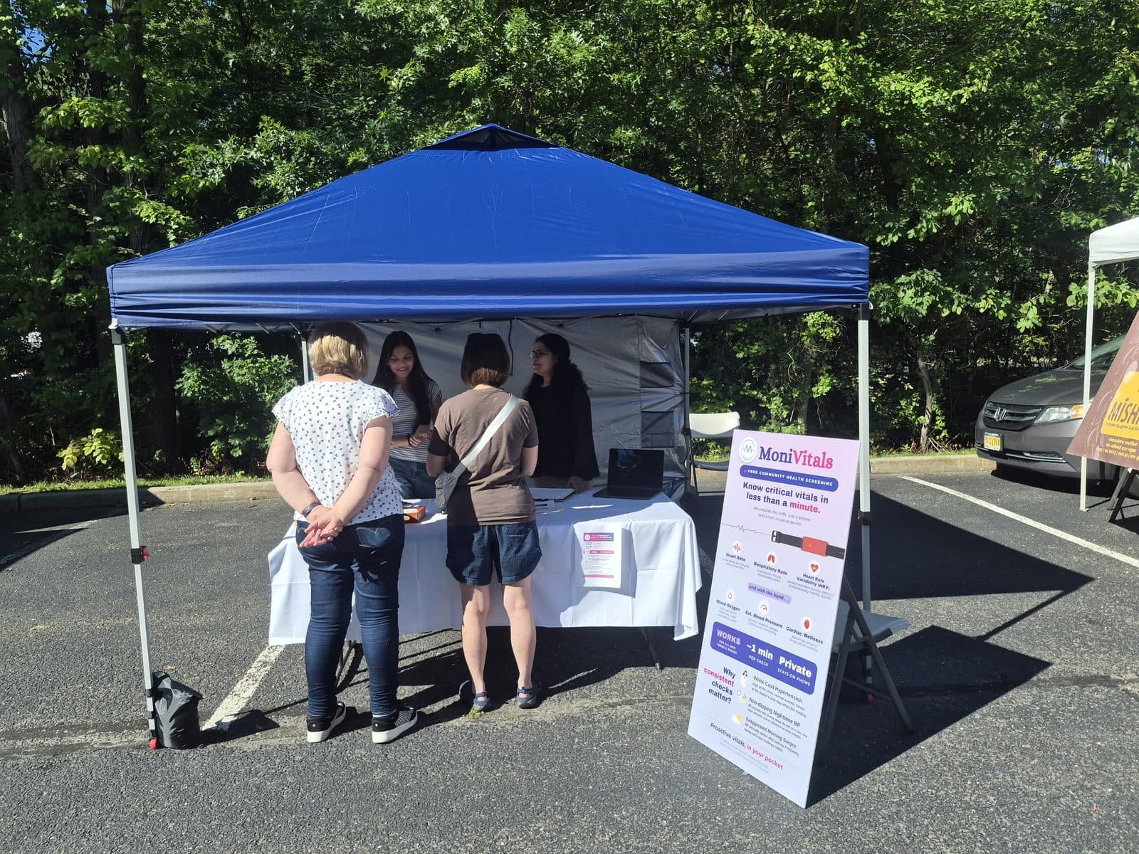 Visitors gathered at the MoniVitals tent at the farmers market
